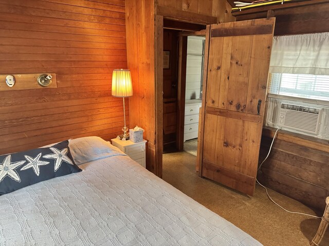 carpeted bedroom featuring cooling unit and wooden walls