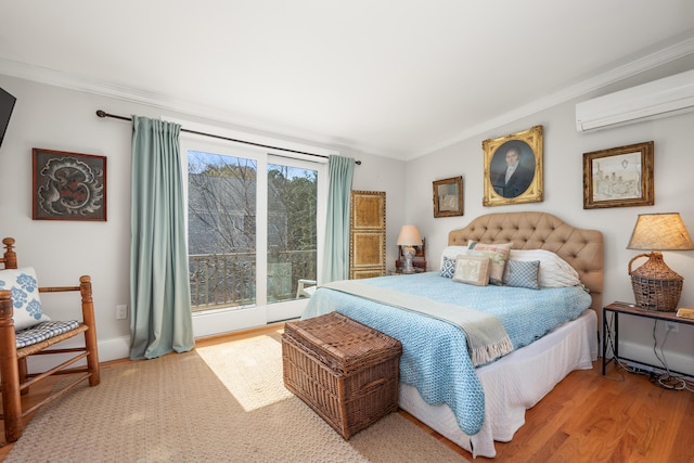 bedroom with ornamental molding, an AC wall unit, and wood finished floors