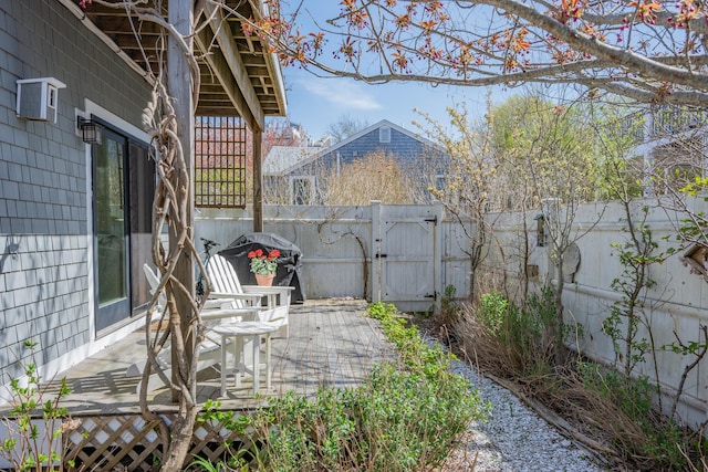 view of patio featuring a fenced backyard, a gate, and a deck