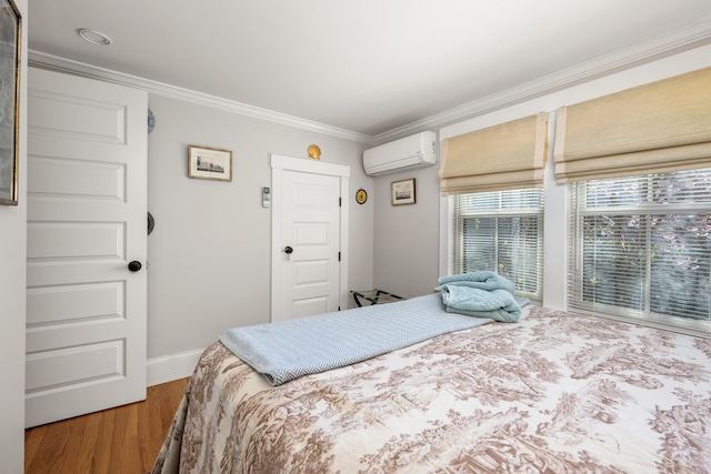 bedroom featuring baseboards, a wall mounted AC, ornamental molding, and wood finished floors