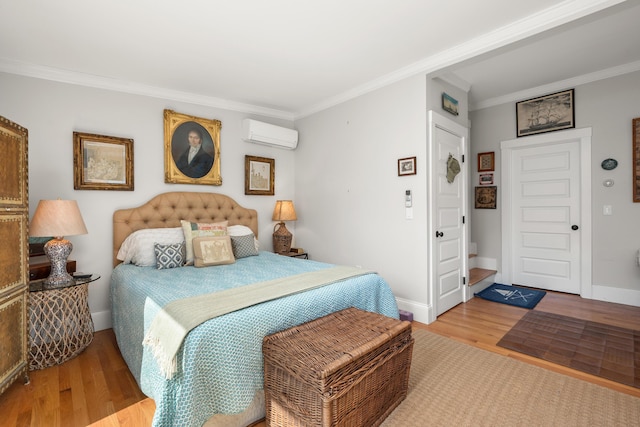 bedroom featuring crown molding, a wall mounted air conditioner, baseboards, and wood finished floors