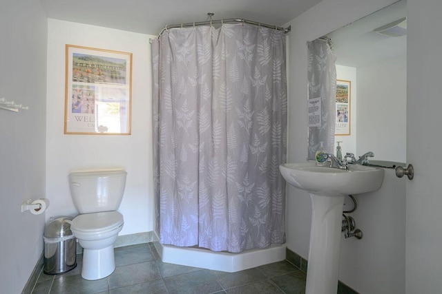 bathroom featuring tile patterned floors, toilet, and a shower with curtain