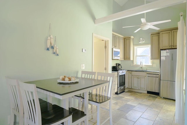 kitchen with ceiling fan, appliances with stainless steel finishes, sink, cream cabinets, and lofted ceiling