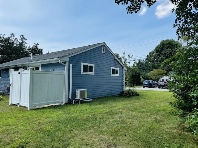 view of home's exterior with central air condition unit and a yard