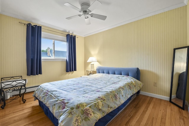 bedroom featuring a baseboard heating unit, hardwood / wood-style flooring, a water view, ceiling fan, and crown molding