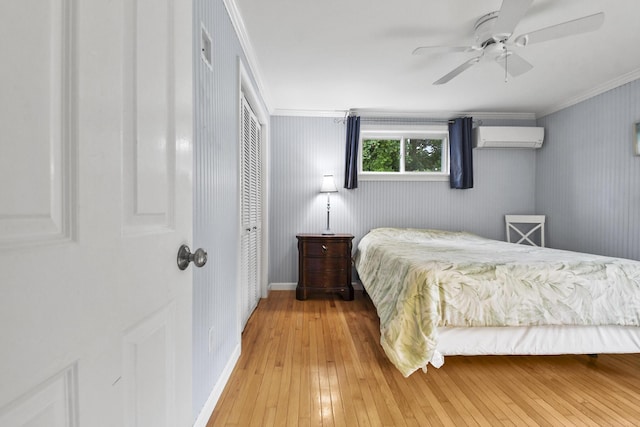 bedroom with ceiling fan, a wall mounted AC, crown molding, and hardwood / wood-style floors