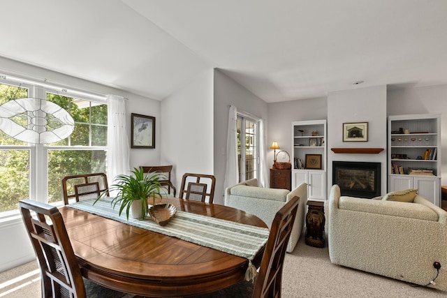 18 W Rd Unit 315, Orleans, MA 02653 - dining space featuring light colored carpet, plenty of natural light, a glass covered fireplace, and built in shelves