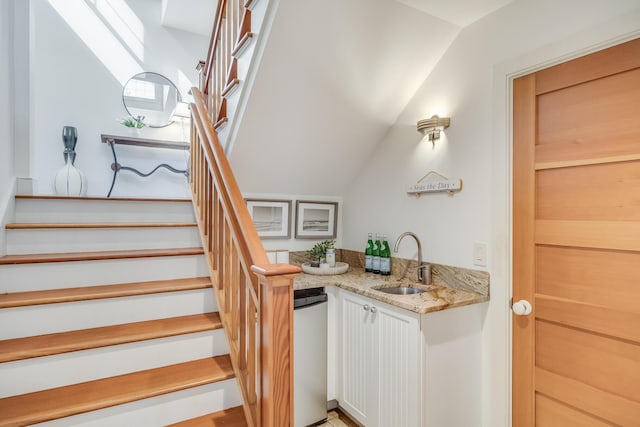 indoor wet bar with vaulted ceiling, stairs, and dishwashing machine