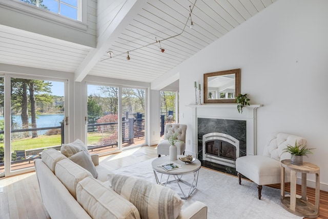 living room featuring wood finished floors, a high end fireplace, a water view, and wood ceiling