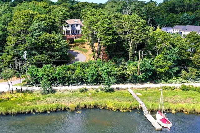 drone / aerial view of a nearby body of water and a forest