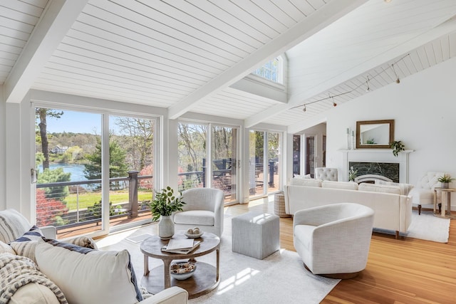 sunroom featuring plenty of natural light, wood finished floors, a water view, and wooden ceiling