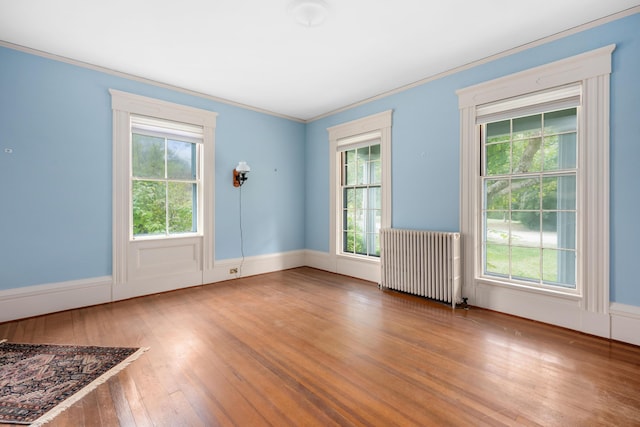 entryway featuring wood-type flooring, radiator heating unit, and crown molding