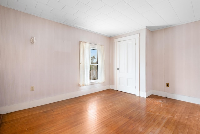 unfurnished room with wood-type flooring and ornamental molding