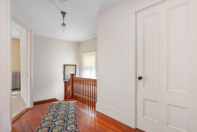 corridor with hardwood / wood-style flooring and radiator