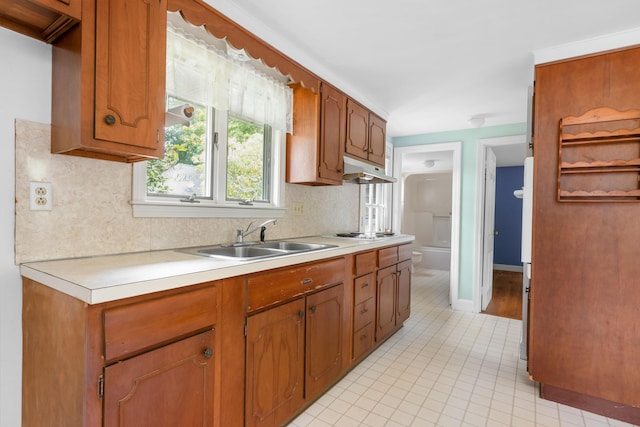 kitchen featuring sink, tasteful backsplash, and white stovetop