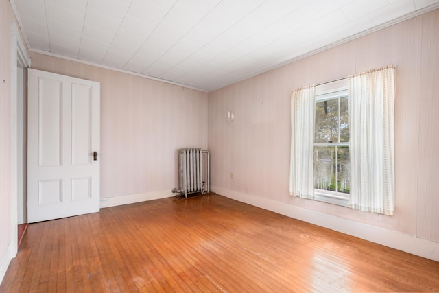 spare room featuring hardwood / wood-style floors and radiator