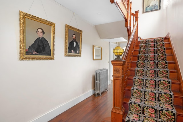 stairway with radiator heating unit and hardwood / wood-style flooring