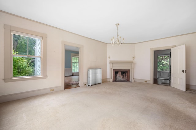 unfurnished living room with carpet flooring, radiator, and an inviting chandelier