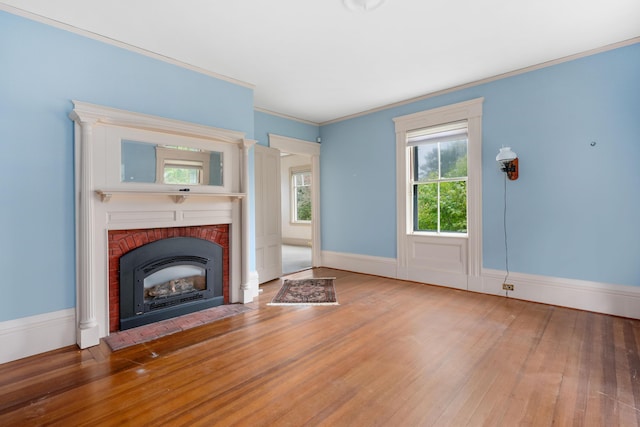 unfurnished living room with a brick fireplace, crown molding, and hardwood / wood-style floors