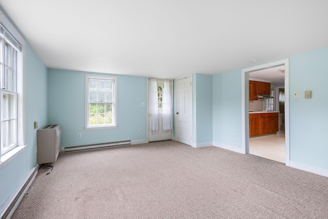 carpeted empty room with a baseboard radiator