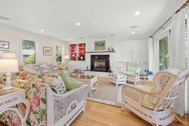 7 Sunrise Ln, Sandwich, MA 02563 - living room with crown molding, light wood-type flooring, recessed lighting, and a glass covered fireplace