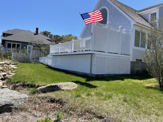 view of home's exterior featuring a wooden deck and a lawn