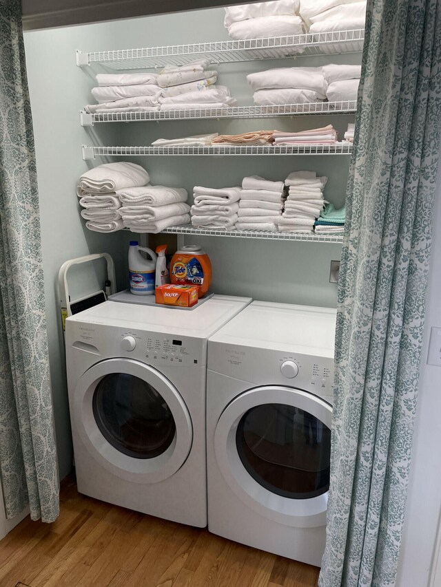 laundry area featuring wood-type flooring and washer and clothes dryer