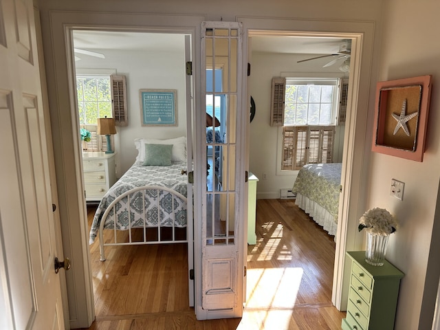 bedroom with ceiling fan, light hardwood / wood-style floors, and a baseboard radiator