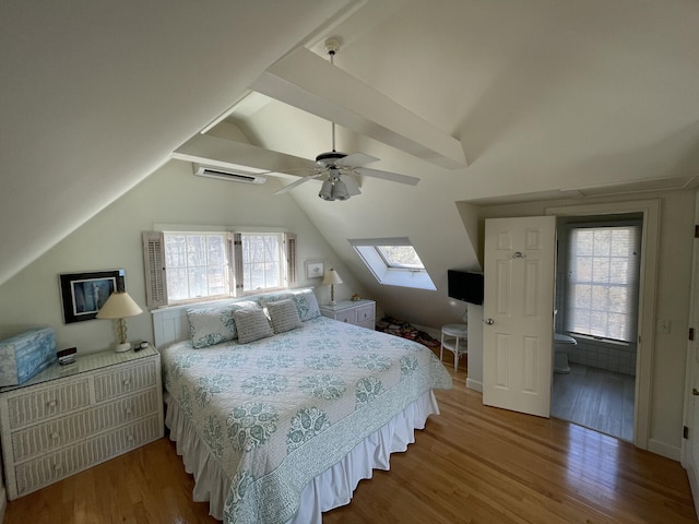 bedroom featuring ceiling fan, hardwood / wood-style flooring, and lofted ceiling with skylight