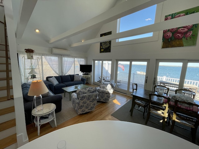 living room with hardwood / wood-style floors, lofted ceiling with beams, and a wall unit AC