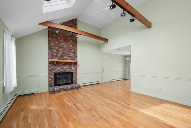 60 Covey Dr, Yarmouth Port, MA 02675 - unfurnished living room featuring visible vents, a skylight, rail lighting, wood finished floors, and a baseboard heating unit