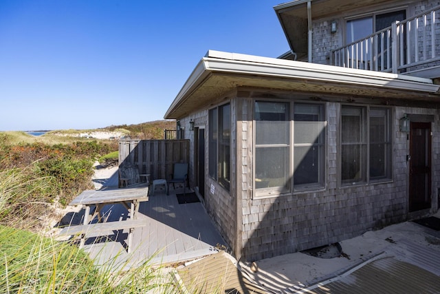 view of property exterior featuring a wooden deck and a balcony