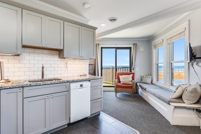 kitchen featuring dishwasher, sink, a water view, tasteful backsplash, and light stone counters