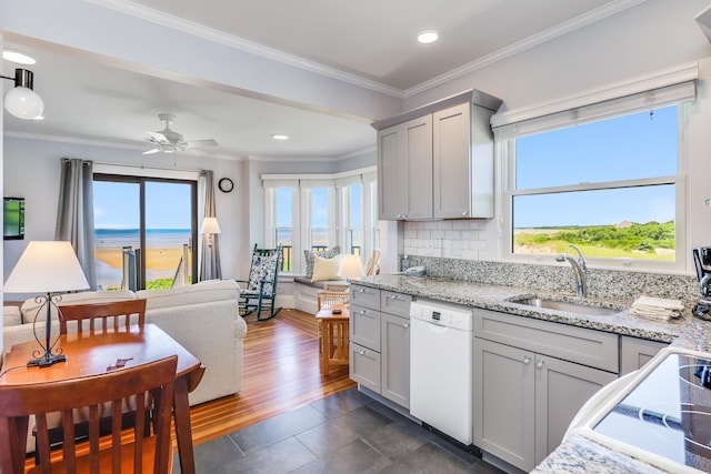 kitchen with sink, a water view, white dishwasher, and gray cabinetry