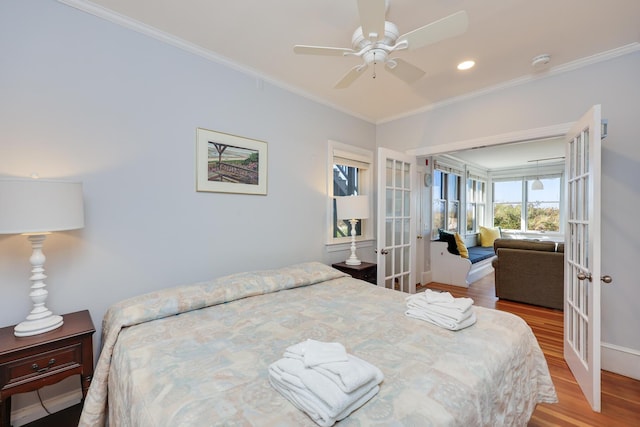 bedroom with crown molding, light hardwood / wood-style flooring, ceiling fan, and french doors