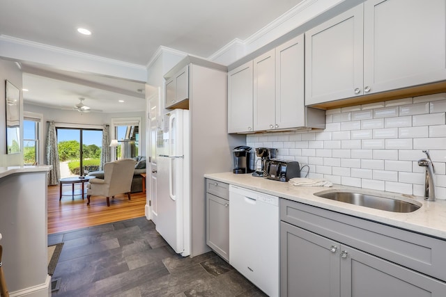 kitchen featuring ceiling fan, sink, tasteful backsplash, light stone countertops, and white appliances