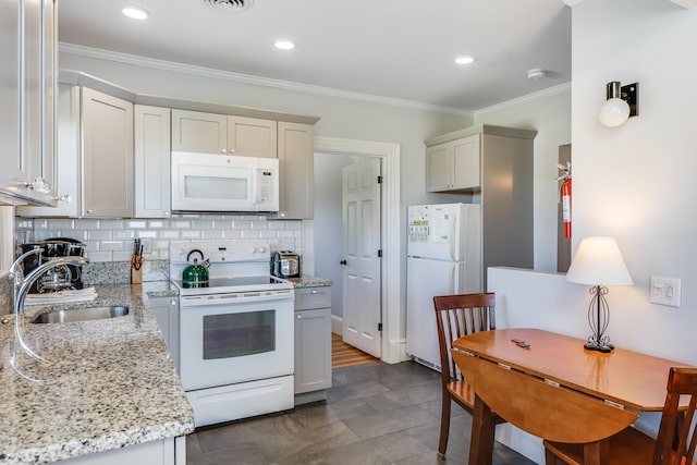 kitchen featuring white appliances, tasteful backsplash, sink, ornamental molding, and light stone counters