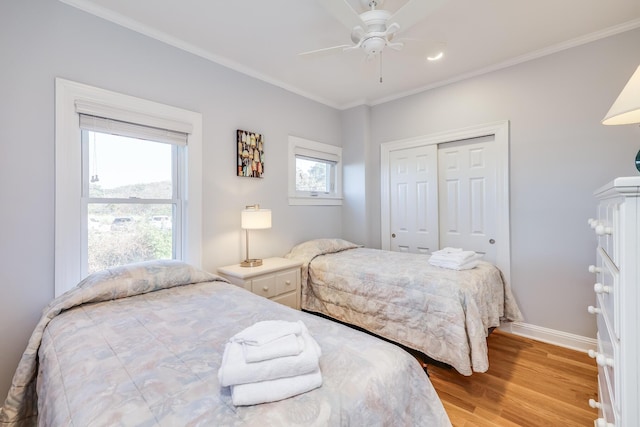 bedroom with ceiling fan, a closet, ornamental molding, and light wood-type flooring