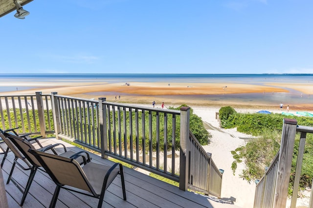 deck featuring a beach view and a water view