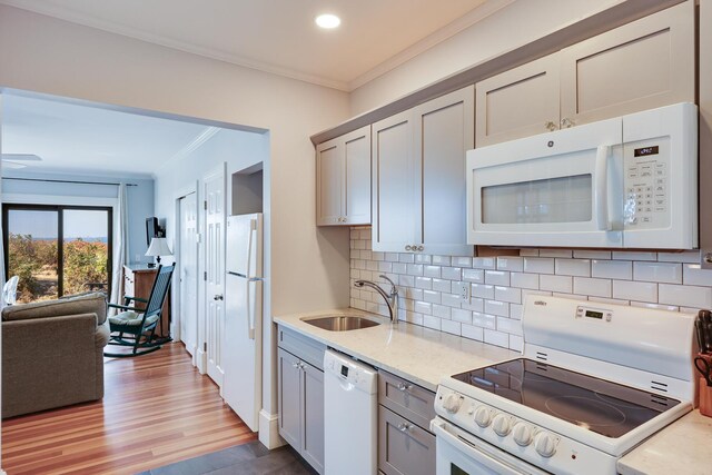 kitchen with sink, white appliances, decorative backsplash, and ornamental molding