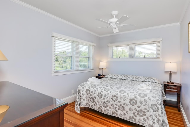 bedroom featuring light hardwood / wood-style floors, multiple windows, ceiling fan, and ornamental molding