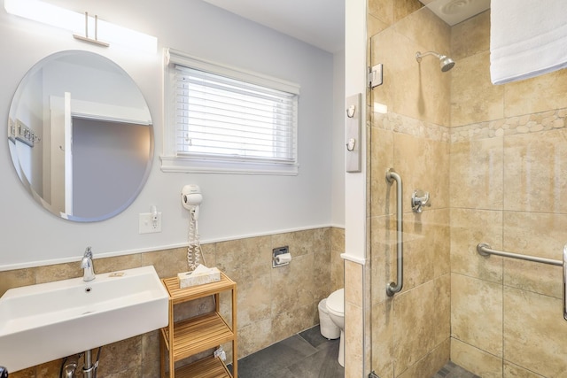 bathroom featuring toilet, walk in shower, tile walls, sink, and tile patterned floors