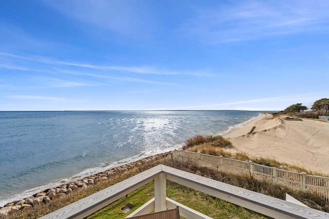 view of water feature with fence and a beach view