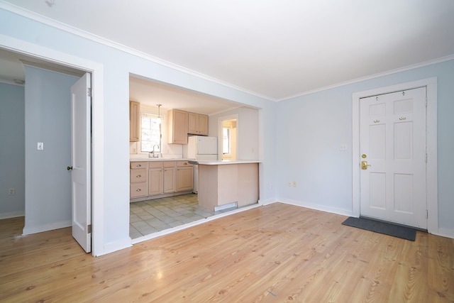 kitchen with crown molding, light countertops, freestanding refrigerator, light wood-type flooring, and a peninsula