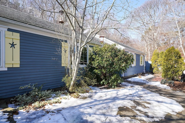 view of property exterior with roof with shingles