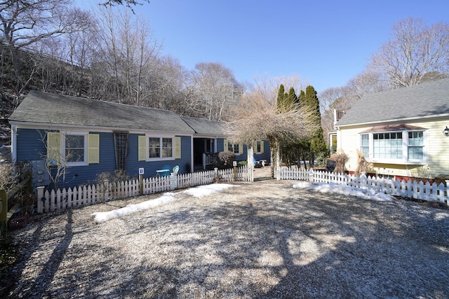 view of front of house with a fenced front yard and roof with shingles