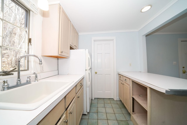 kitchen featuring crown molding, a sink, light countertops, freestanding refrigerator, and light tile patterned floors