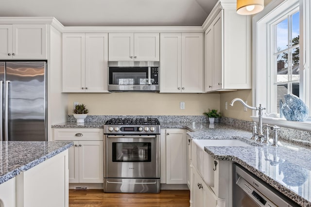 29 Hiawatha Rd, Harwich Port, MA 02646 - kitchen with light stone counters, white cabinetry, appliances with stainless steel finishes, and wood finished floors