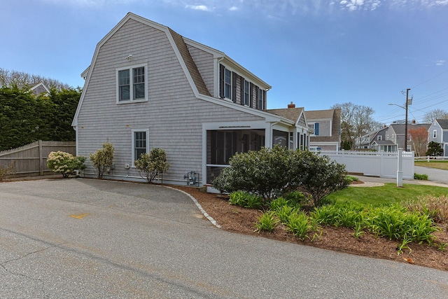 29 Hiawatha Rd, Harwich Port, MA 02646 - view of side of home with fence, a sunroom, and a gambrel roof