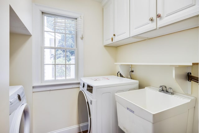 laundry area featuring a sink, cabinet space, a wealth of natural light, and washing machine and clothes dryer